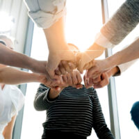 Ein Team hält die Fäuste in Sternform aneinander.